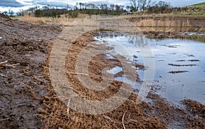 Biodegradable silt sediment net trap along a drainage channel