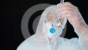 Bioengineer looking at test tube with colorless liquid isolated on white background. Medical worker analyzes liquid in