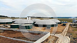 Biogas. Aerial view of a biogas plant and a farm in green fields. Renewable energy from biomass. Modern agriculture in Ukraine and