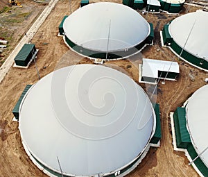 Biogas. Aerial view of a biogas plant and a farm in green fields. Renewable energy from biomass. Modern agriculture in Ukraine and