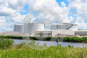 Biogas plant with large biomass digesters along a canal