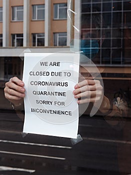 Biohazard concept of living in a new reality of coronavirus epidemy hysteria cafÃ© owner sticks advertisement on quarantine