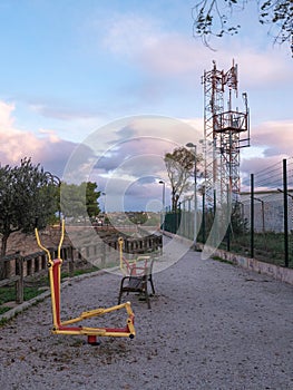 Biohealthy circuit for the elderly with two exercise equipment in a park with a wooden fence walkway