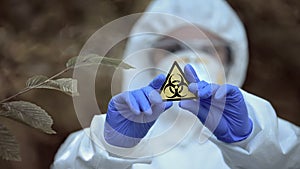 Biological hazard sign in researcher hands, health threat, virus danger, toxin