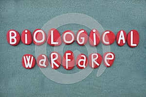 Biological Warfare text composed with red stone letters over green sand