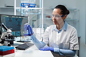 Biologist doctor holding transparent glassware analyzing blue solution