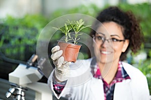 Biologist holding pot with sprout