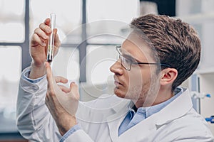 Biologist with plant in flask