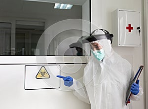 Biologist showing biohazard sign in laboratory