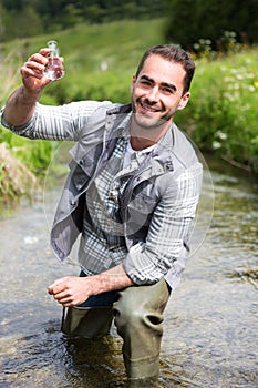 Biologist take a sample in a river in order to do some test