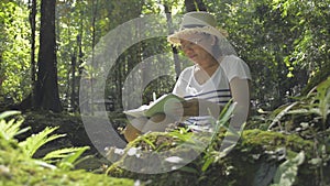 Biologist taking note about natural data and ecosystem in tropical forest.