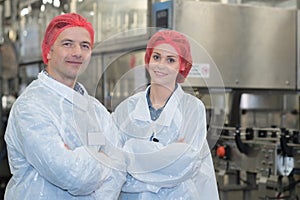 Biologist team talking and wearing hairnet in factory