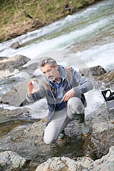 Biologist testing quality of river water