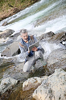 Biologist testing water quality of river