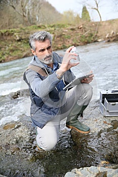 Biologist testing water quality of river