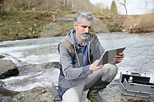 Biologist testing water quality of river