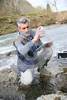 Biologist testing water quality of river photo