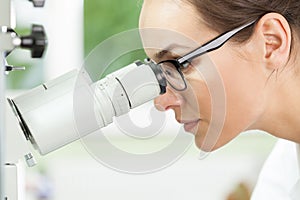 Biologist using microscope at work