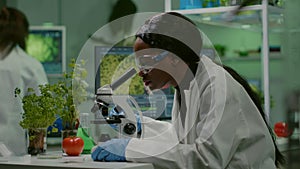 Biologist woman looking at test sample under microscope