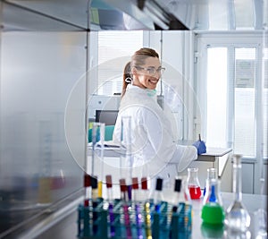 Biologist working with chemical bottles in incubator