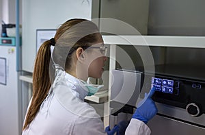 Biologist working on display of incubator in laboratory