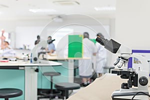 Biology or chemistry science class study with microscope and blur background of school student group learning in blurry lab