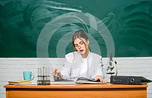 Biology student sit classroom chalkboard background. Scientific research. Chemist biologist with microscope. Smart