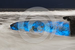 Bioluminescent tide glows on some rocks in La Jolla, California