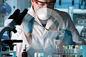 Biomedical engineer working with samples in microplate in the la photo