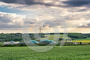 Biomethane plant between fields in rural area at sunset