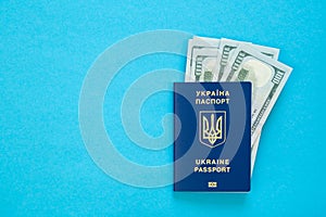 Biometric Ukrainian passport and money on a blue background, copy space.