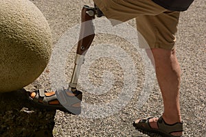 Bionic carbon leg prosthesis of a man, left leg prosthesis self-assured man wearing shorts