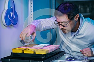 Biotechnology concept with scientist in lab. Scientist watering a plant with a special solution.