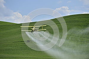 Biplane Crop Duster spraying a farm field. photo