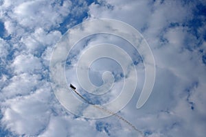 BIPLANE DISPLAY AGAINST CLOUDS TRAILING SMOKE