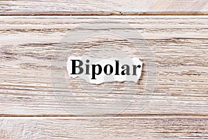 BIPOLAR of the word on paper. concept. Words of BIPOLAR on a wooden background
