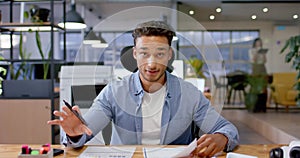 Biracial casual businessman talking during video call, working late at office, in slow motion