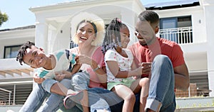 Biracial family enjoys a sunny day together outdoors, smiling.