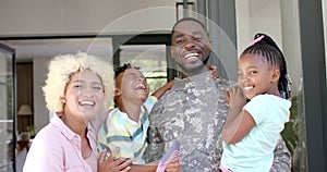 Biracial family joyfully reunites with soldier dad in a warm home.