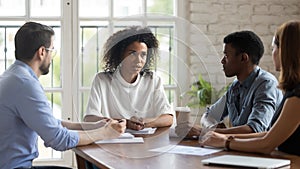 Biracial female boss lead meeting with diverse employees