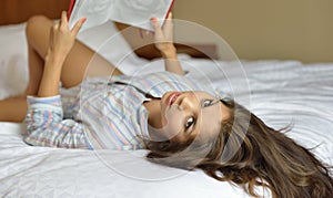 biracial female model - reading journal in bed