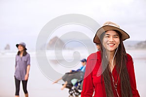 Biracial teen girl in red dress and hat  at beach