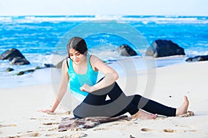 Biracial teen girl stretching and exercising on beach