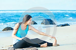 Biracial teen girl stretching and exercising on beach