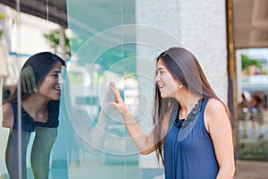 Biracial teen girl window shopping in urban setting downtown