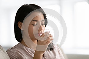 Biracial woman drink pure mineral water from glass
