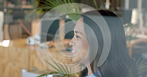 Biracial woman smiles in a bright business office setting with copy space