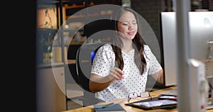 Biracial woman stretches at her business desk in the office