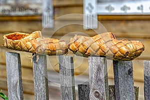 Birch bast shoes hang on fence