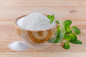 Birch sugar xylitol in a wood bowl with mint on wooden